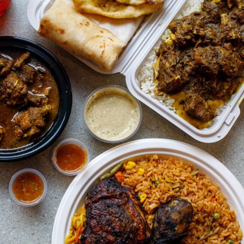 An appetizing assortment of traditional African foods including rice, meats, and sauces on a table.